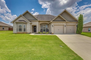 A two-story house with a front porch, a garage, and a well-maintained lawn.