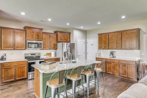 A kitchen with wooden cabinets, stainless steel appliances, and a granite countertop.