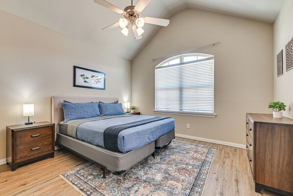 A bedroom with a bed, nightstand, dresser, ceiling fan, window with blinds, and a rug. - Lewisville Home w/ Pool Access: Walkable Location (Lewisville)