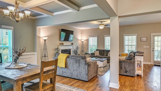 A spacious living area with a fireplace, sofas, and a television.