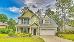 A two-story house with a front porch, a garage, and a well-maintained lawn.