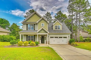 A two-story house with a front porch, a garage, and a well-maintained lawn. - Stay & Play! Pinehurst Family & Group Golf Retreat (Pinehurst)