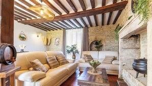 Un salon chaleureux avec un canapé, une table basse et un mur en pierre.