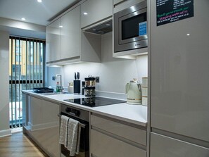 A modern kitchen with stainless steel appliances, a built-in microwave, and a coffee maker. - Modern 1Bed Central Leeds Apt Near Arena (Leeds)