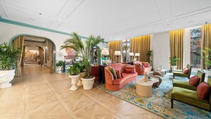 A spacious lobby with a curved sofa, multiple armchairs, potted plants, and a patterned rug. - Private Residence at Nomad Wynwood Residencs - 532 (Miami)