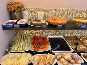 Un bufé con diversas opciones de comida, incluyendo frutas, ensaladas y postres.