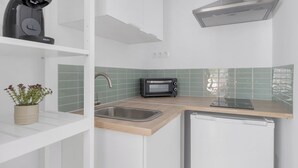 Eine moderne Küche mit integriertem Mikrowellenherd, Spüle und einem kompakten Kühlschrank.