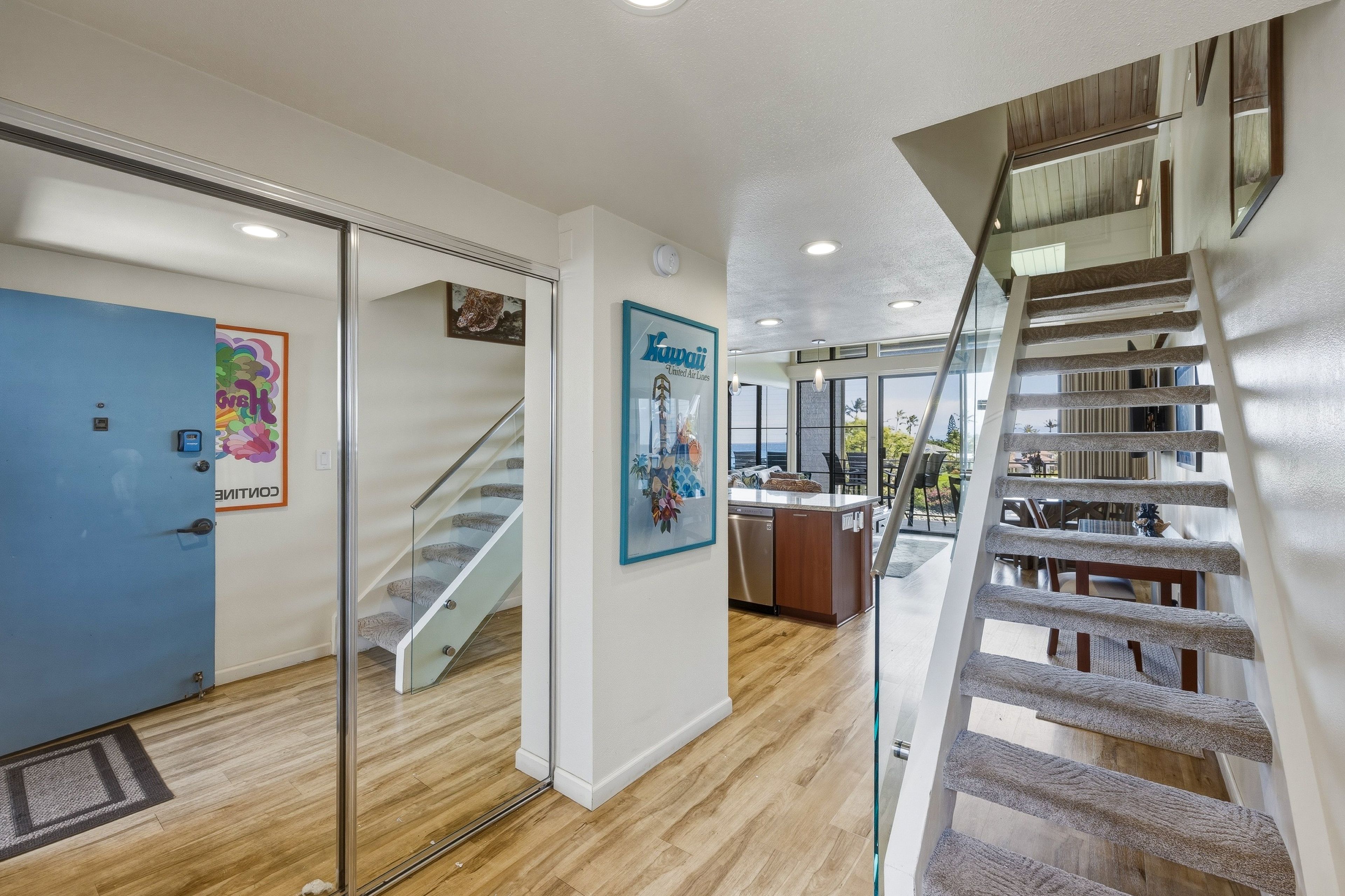 L’intérieur d’un hôtel, avec un escalier, un coin cuisine et une vue sur l’extérieur.