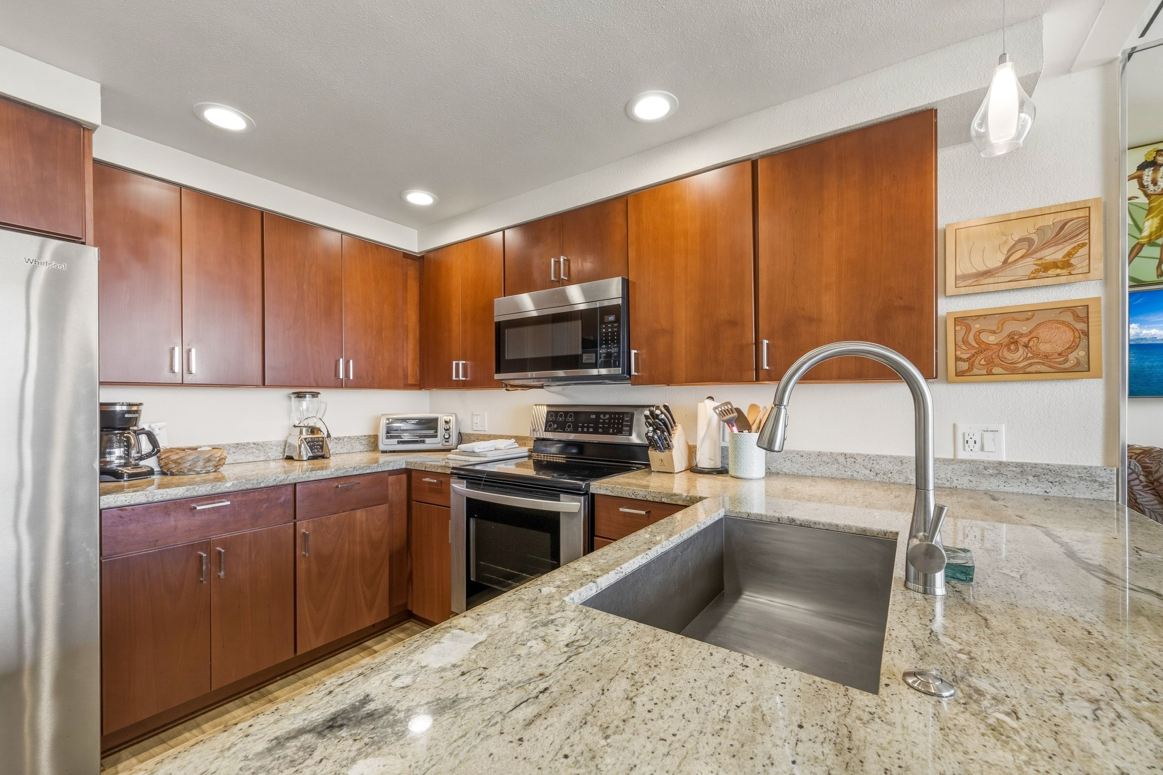 A modern kitchen with wooden cabinets, stainless steel appliances, a granite countertop, and a built-in sink.