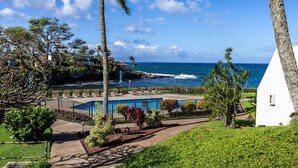 A pool area with lounge chairs and a view of the ocean. - Ocean View 2BR Loft Near Napili Beach - Unit C34 (Lahaina)