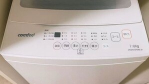 Eine kompakte, weiße, an der Wand montierte Kaffeemaschine mit digitaler Anzeige und mehreren Tasten, darunter ein Ein-/Ausschalter und eine Stärkeauswahl.