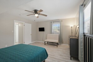 A bedroom with a bed, a chair, a ceiling fan, a TV, and a radiator. - Private Pool Oasis 15 Mins To World Cup Sleeps 10 4 Bedroom Home (Decatur)