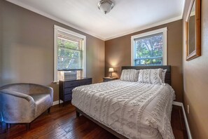 A bedroom with a bed, a chair, a dresser, and two windows. - Easy Stay 3 Bedroom Home (Hood River)