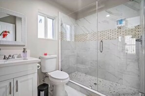 A bathroom with a glass-enclosed shower, a toilet, and a sink with a mirror. - Private Santa Clarita Retreat w/ Patio Slps 8 (Santa Clarita)