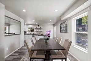 A dining area with a long table, chairs, and a vase of flowers. - Private Santa Clarita Retreat w/ Patio Slps 8 (Santa Clarita)