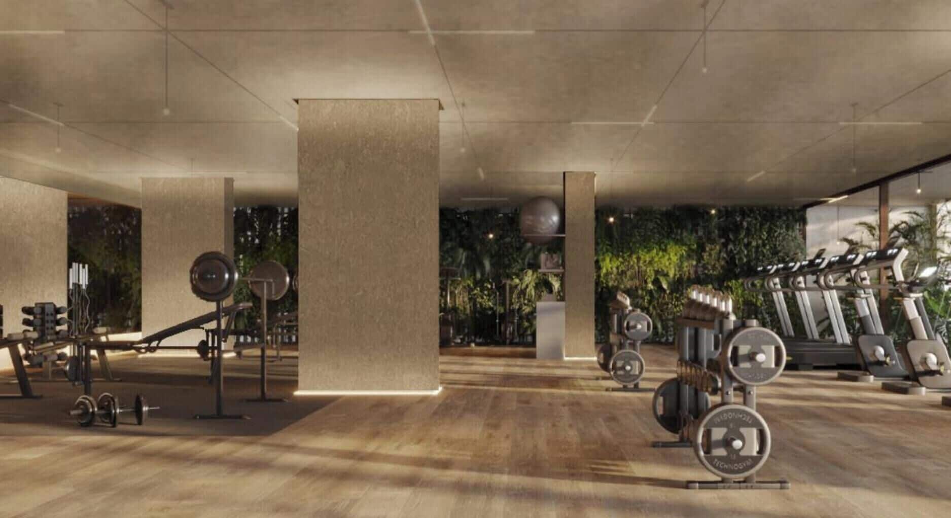 A spacious gym with various exercise equipment, including treadmills and weight machines, and a large pillar in the center.