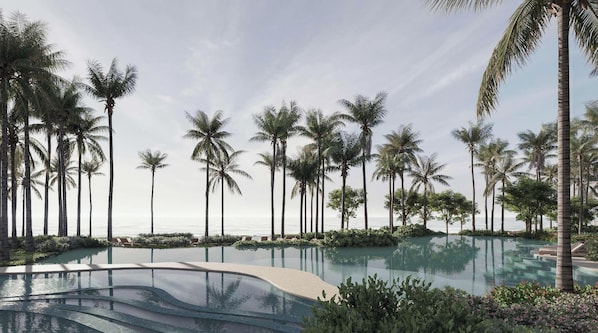 Un resort con una amplia piscina infinita rodeada de palmeras y vistas al océano.