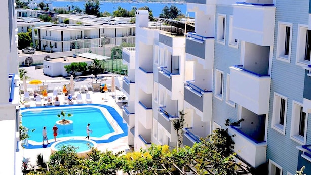 A hotel with a swimming pool, multiple balconies, and a view of the sea. - Sunpoint Hotel Bodrum (Bodrum)