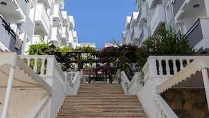 A staircase leading to a building with white balconies and a clear blue sky. - Sunpoint Hotel Bodrum (Bodrum)
