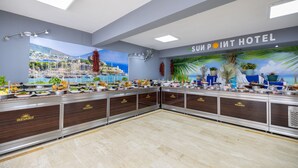 A buffet setup with a view of a coastal town, a ceiling with recessed lighting, and a sign reading 'SUN POINT HOTEL'. - Sunpoint Hotel Bodrum (Bodrum)