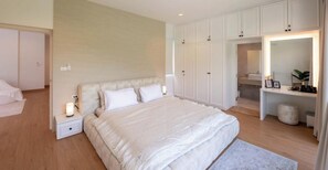 Ein Schlafzimmer mit Bett, Nachttischen, einem Kleiderschrank und einem Frisiertisch mit Spiegel.