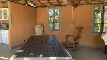 A room with a wooden table, two rocking chairs, a window, and a door.