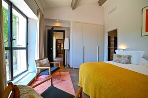 A bedroom with a bed, a chair, a bedside table, a lamp, and a wardrobe. - Le Domaine de Laudun · 8 bedrooms · private pool (Tarascon)