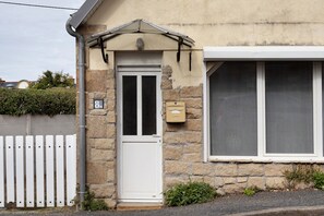 A stone house with a white door, a mailbox, and a window. - Holiday Home 'Maison De Molène' with Sea View (Trébeurden)