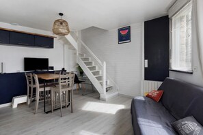 A modern kitchen with a dining area, a staircase, and a living room with a sofa. - Holiday Home 'Maison De Molène' with Sea View (Trébeurden)