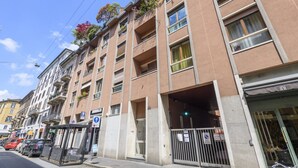 A multi-story building with balconies, a bus stop, and a gated entrance. - PALERMO, 14 – Garibaldi/Brera Modern Suite (Milan)