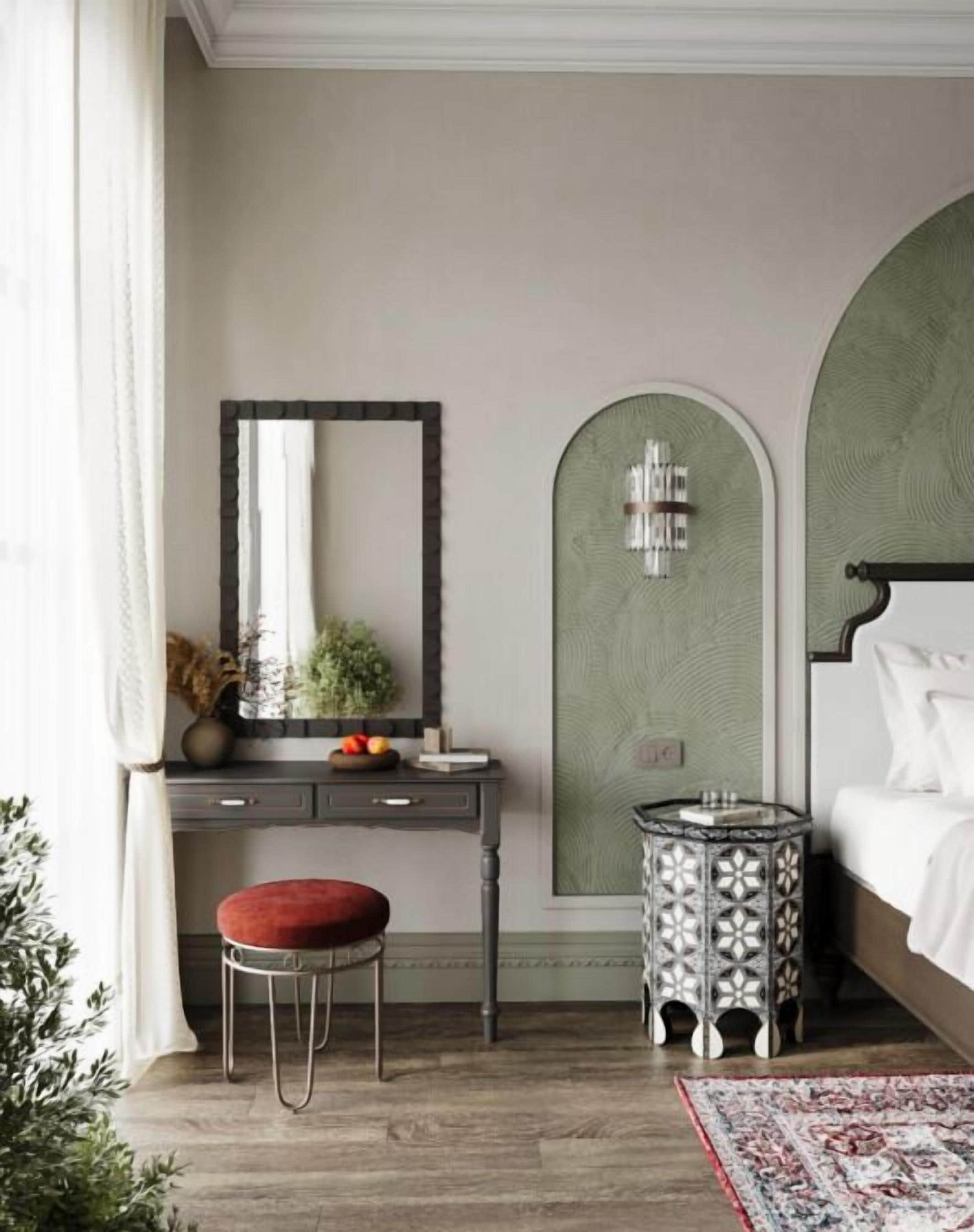 A bedroom with a bed, a bedside table, a mirror, a dresser, and a small round table with a patterned top.