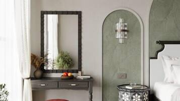 A bedroom with a bed, a bedside table, a mirror, a dresser, and a small round table with a patterned top.