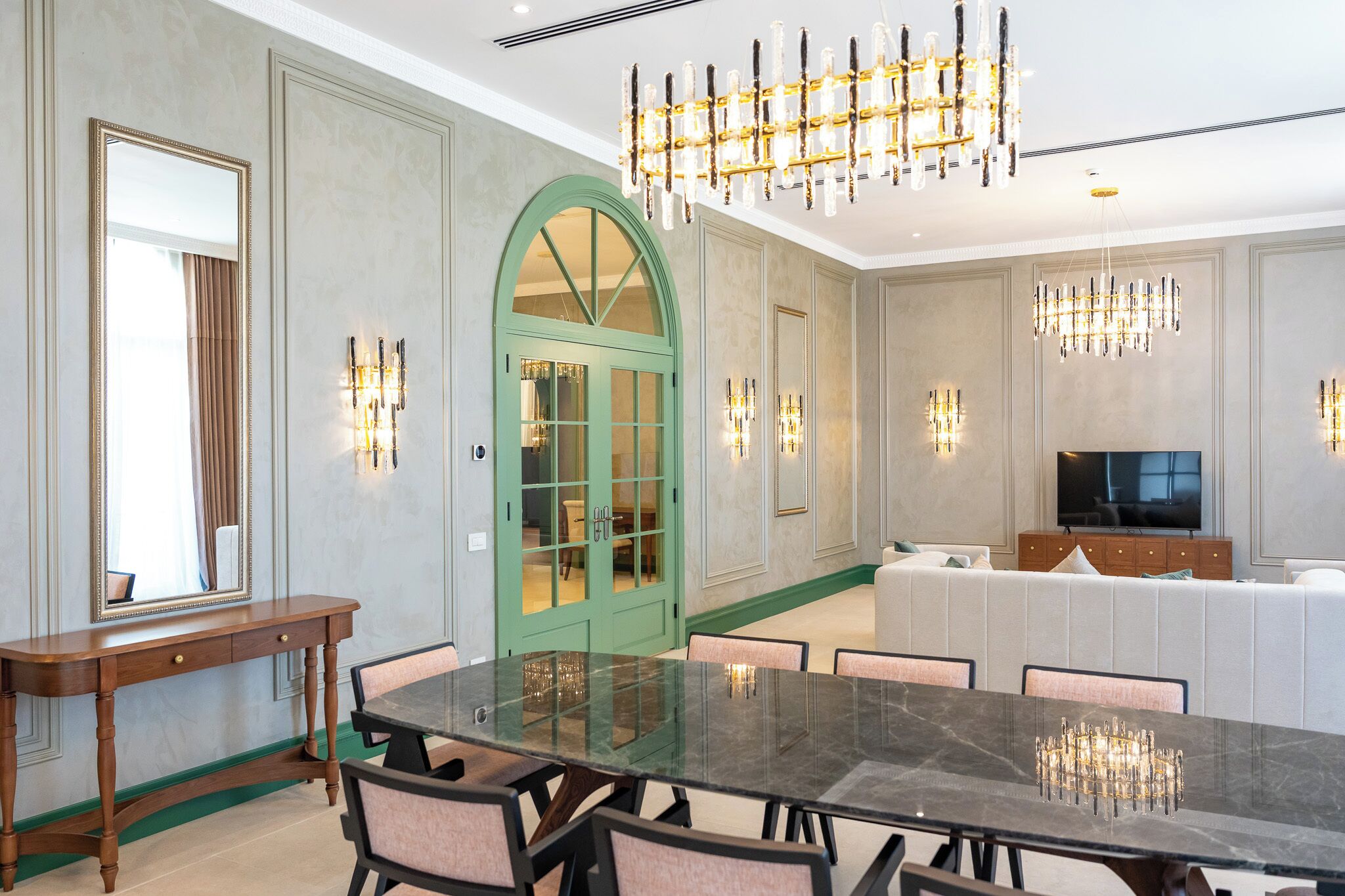 Un comedor espacioso con una gran mesa de mármol, sillas modernas e iluminación elegante.