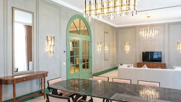 Un comedor espacioso con una gran mesa de mármol, sillas modernas e iluminación elegante.