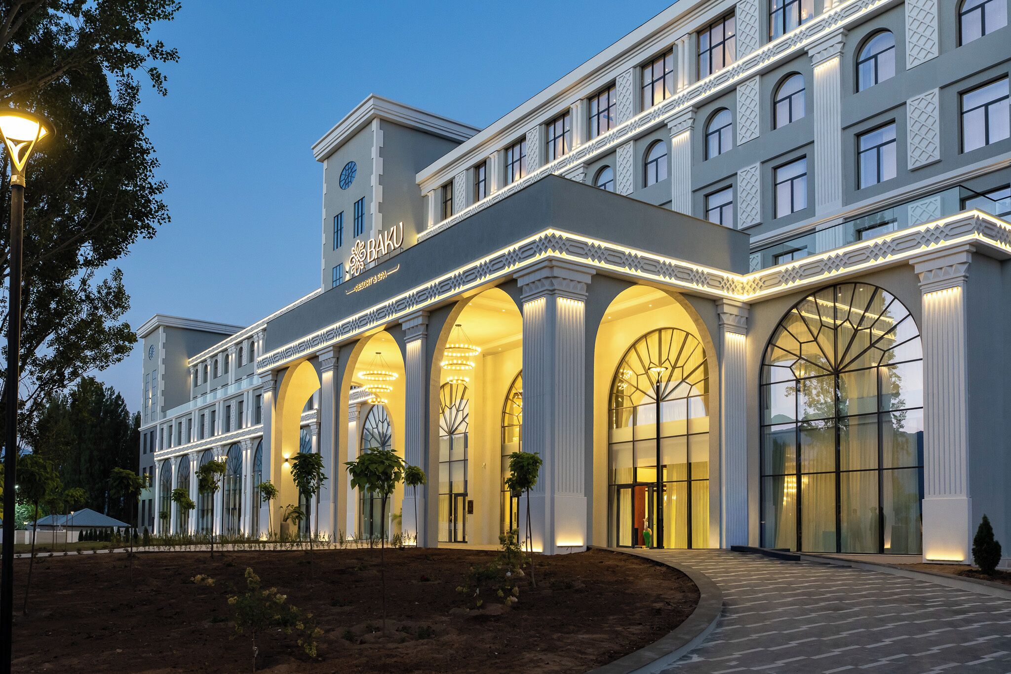 A hotel with a classic architectural style, featuring arched windows and a central entrance.