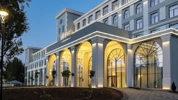 A hotel with a classic architectural style, featuring arched windows and a central entrance.