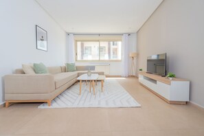 Ett modernt vardagsrum med en soffa, ett soffbord, en tv och ett element.