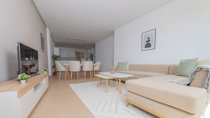 A modern living room with a sofa, coffee table, and dining area. - Appartement Charmant a hydra (Algiers)