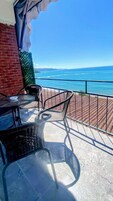 Un balcón con vistas al mar, que incluye una mesa y dos sillas.