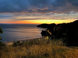 A coastal landscape with a road curving along the cliffside, overlooking the sea.