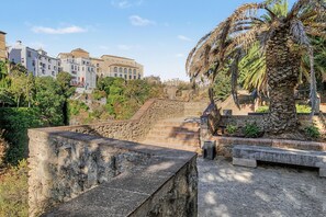 A stone staircase leading up to a building with a flat roof, surrounded by greenery and palm trees. - Apartment 'La Mina' with Terrace, Wi-Fi and Air Conditioning (Ronda)