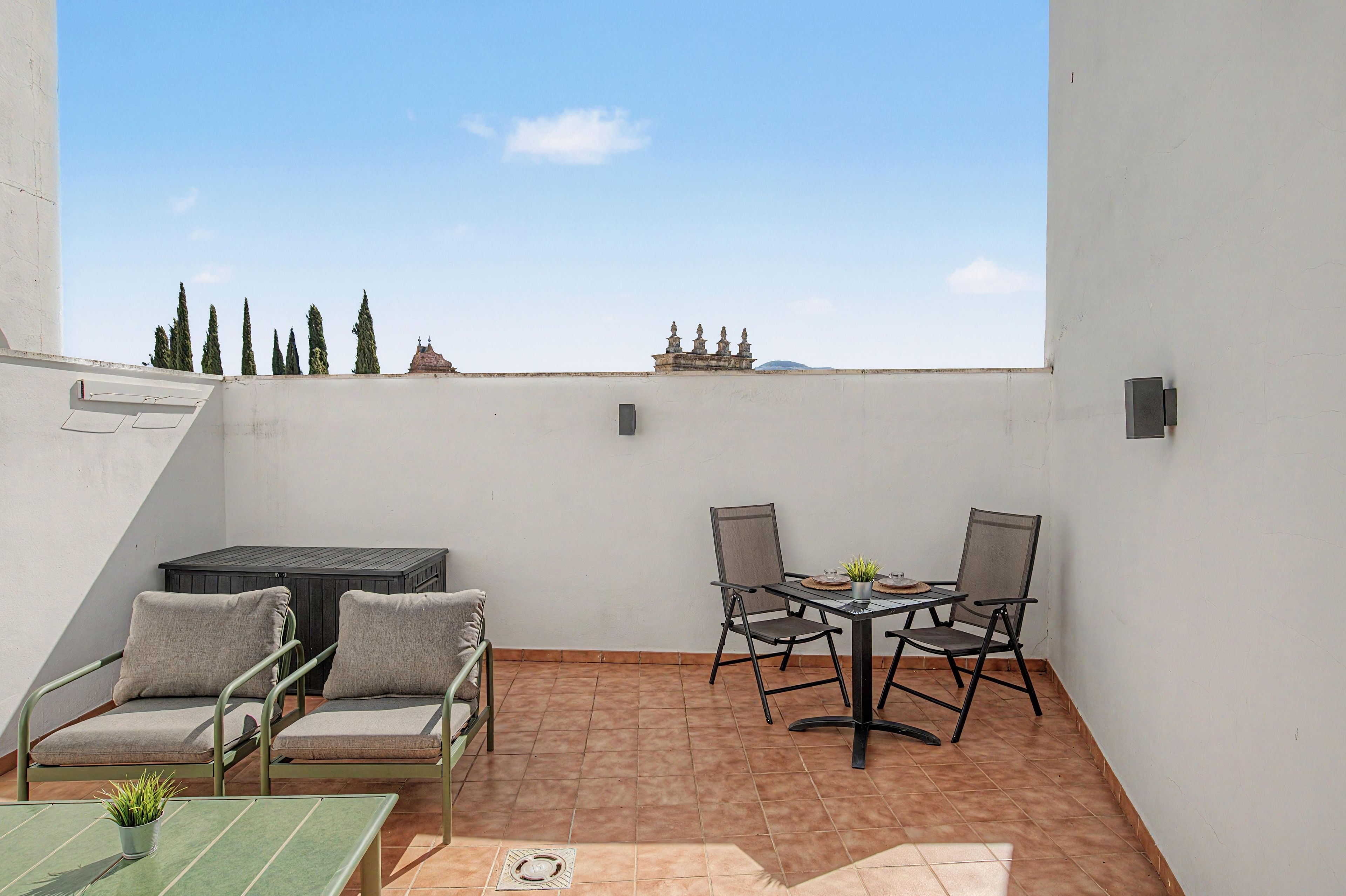 Eine Dachterrasse mit Tisch, Stühlen und einer Sitzecke.