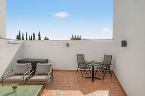 A rooftop terrace with a table, chairs, and a sofa. - Apartment 'La Mina' with Private Terrace, Wi-Fi and Air Conditioning (Ronda)