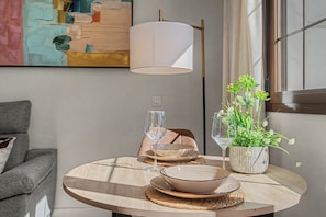 A round wooden table with a glass wine glass, a bowl, and a decorative plant in a ceramic pot. - Apartment 'La Mina' with Private Terrace, Wi-Fi and Air Conditioning (Ronda)