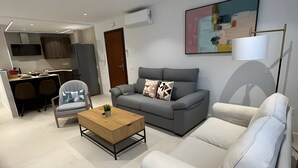Un soggiorno moderno con un divano grigio, una poltrona bianca, un tavolino in legno e un divano grigio.