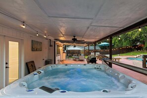 Un jacuzzi en un espacio exterior cubierto con vistas a un jardín.