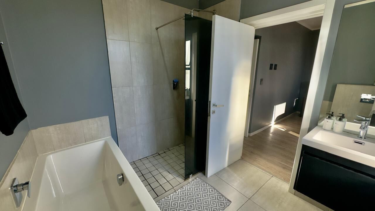 Bathtub dan shower terpisah, sandal, handuk, dan sabun