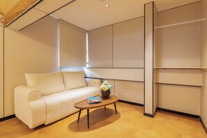 Uma sala de estar moderna com um sofá, uma mesa de centro com livros e um vaso de flores.