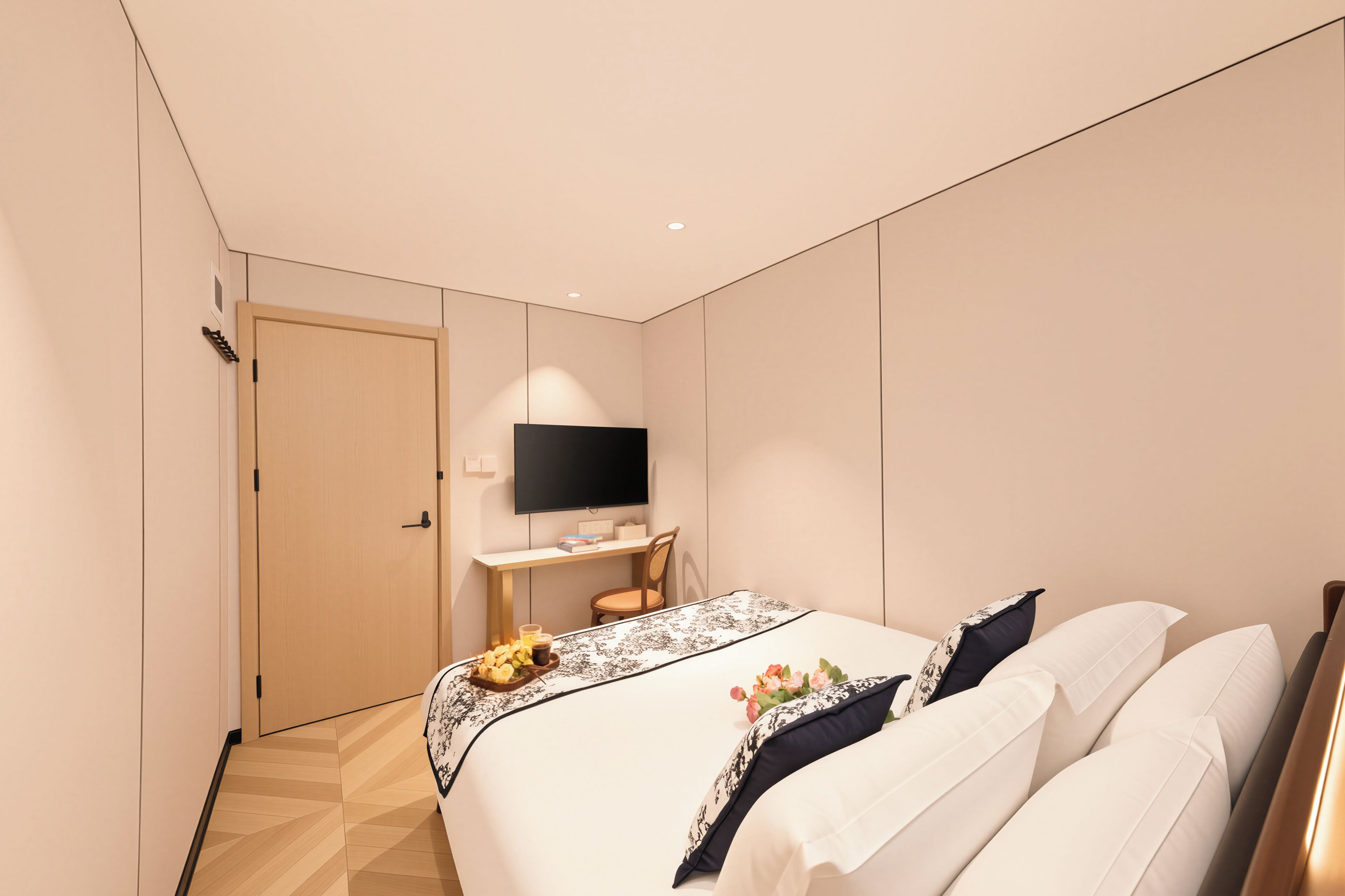 A modern hotel room with a bed, a desk, a flat-screen TV, and a door.