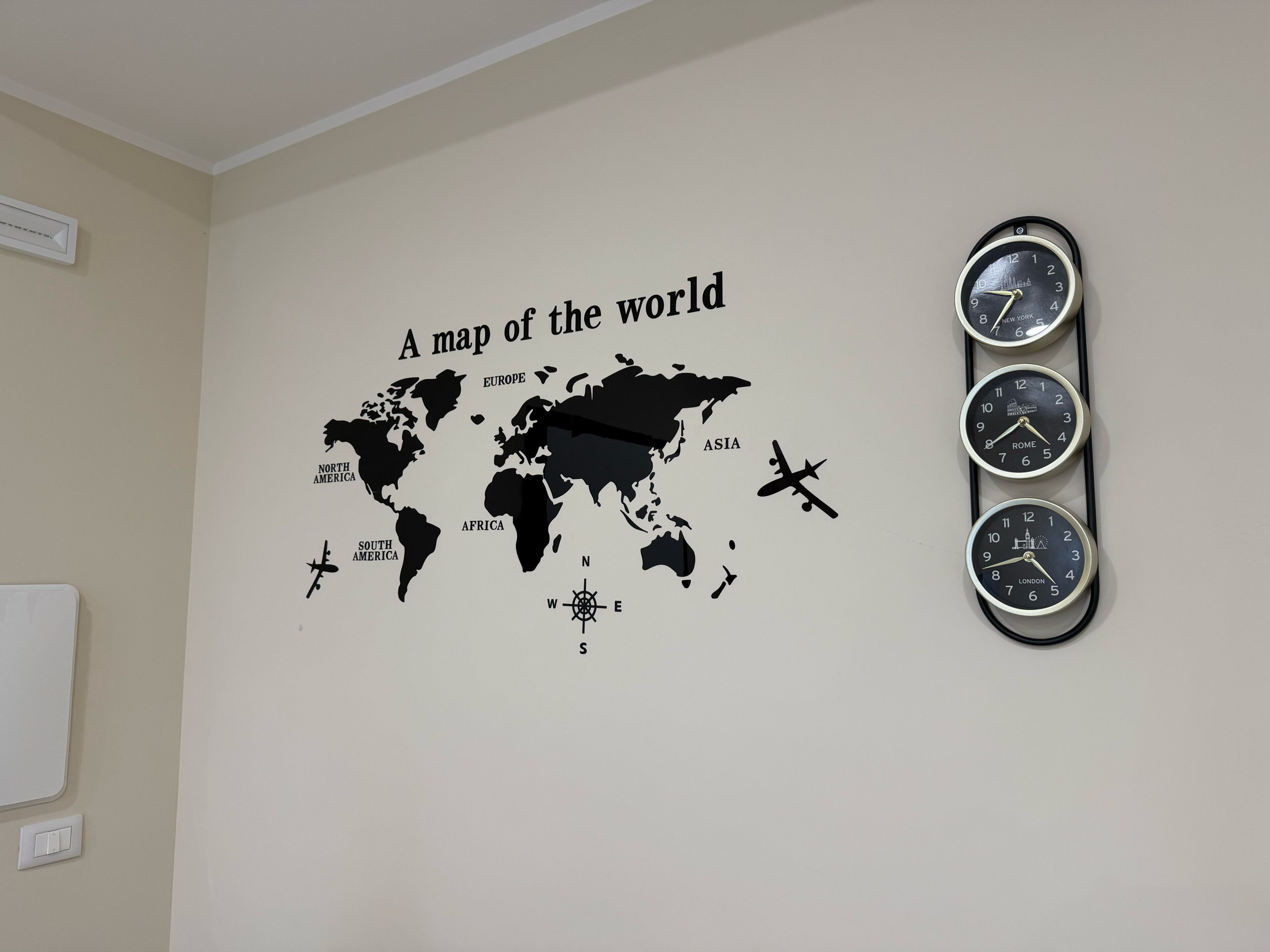 Eine Wand mit einer Weltkarte und einer Uhr, die die Zeiten verschiedener Städte anzeigt.